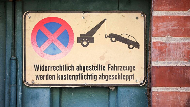 Ein Schild an einem Garagentor weist darauf hin, das widerrechtlich abgestellte Fahrzeuge abgeschleppt werden.