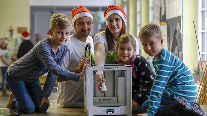 Studentin Elisia Heinrich zeigt Selma, Kurt und Clemens den 3D Drucker.