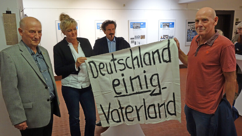 Das Banner, das Klaus Vogelgesang (r.) an Kathrin Fuchs vom Stadtmuseum übergeben hat, wurde bei einer Demonstration im November 1989 entrollt. Jürgen Dettmer (M.) hielt einen Vortrag über die Zeit der Wende in Döbeln.