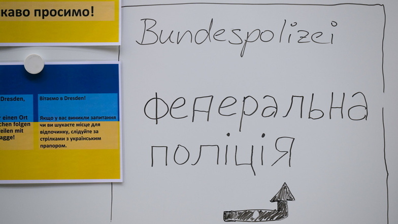 Hinweisschilder und das Wort "Bundespolizei" sind für Flüchtlinge aus der Ukraine auf dem Dresdner Hauptbahnhof in deutscher und ukrainischer Sprache an einer Tafel am Bahnsteig angebracht.