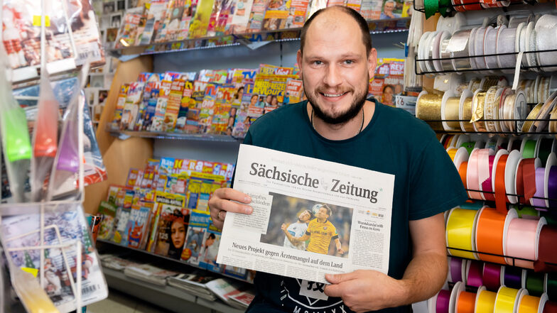 Rico Förster steht vor dem neuen Regal mit Zeitungen und Zeitschriften. Kunden finden darin natürlich auch die SZ.