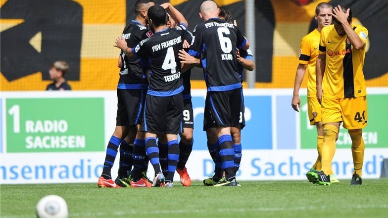 Frankfurts Spieler jubeln nach dem 0:2 während sich Dresdens Cristian Fiel (r) an den Kopf fasst.