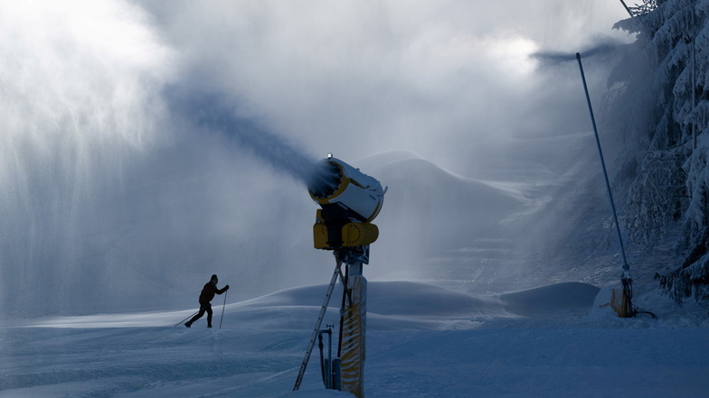 Altenberg: Ein Skifahrer fährt zwischen Schneekanonen über einen Skihang. Im Osterzgebirge läuft die Skisaison noch.