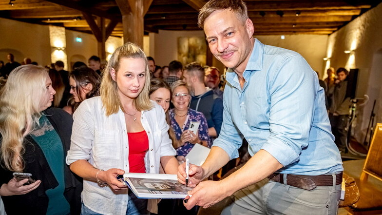 Erst lesen und reden, dann schreiben: Tom Wlaschiha gibt nach der Veranstaltung am Sonnabend auf Burg Stolpen Anne Scherling aus Pirna ein Autogramm.