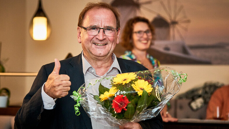 Daumen nach oben, Blumenstrauß in der Hand. Jürgen Opitz startet in die zweite volle Amtszeit.