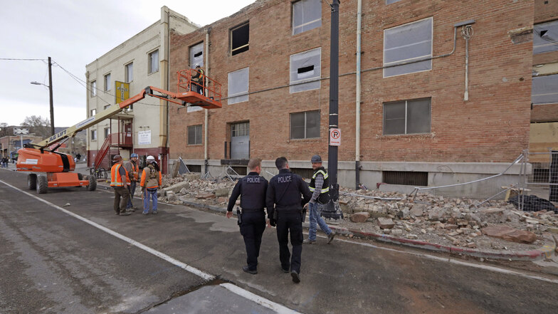 Polizeibeamte gehen nach dem Erdbeben an den Trümmern vorbei. 