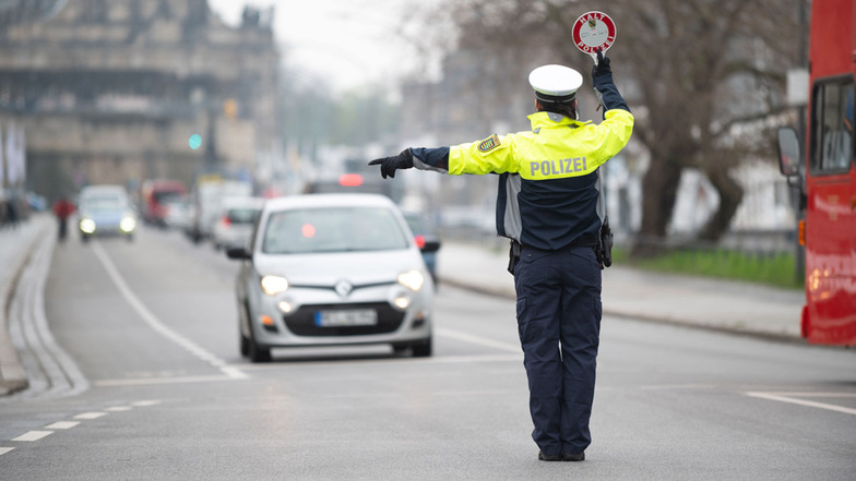 Eine Polizistin lotst am Terrassenufer Autofahrer in die Kontrollstelle in einer Seitenstraße.