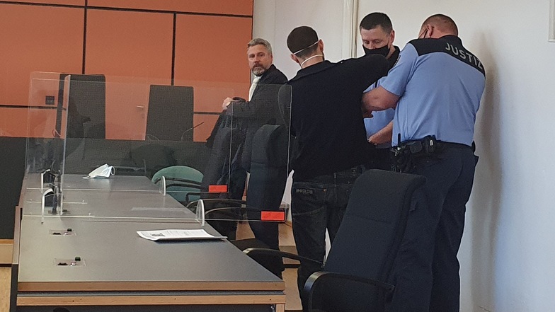 Prozessauftakt im Landgericht Dresden: Wachtmeitser nehmen dem Angeklagten Patrick K. (2.v.l.) die Handfesseln ab. Links sein Verteidiger Matthias Engel.