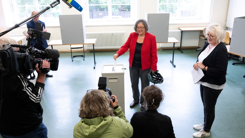 Eva Jähnigen wirft bei der Stimmabgabe für den zweiten Wahlgang zur Oberbürgermeisterwahl in einem Wahllokal in einem Beruflichen Schulzentrum ihren Stimmzettel in die Wahlurne.
