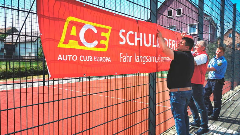 Oberbürgermeister Frank Höhme, Ilko Keßler (Vorsitzender ACE Auto Club Europa e. V. Region Ost) und Polizeihauptmeister Oliver Ott
bringen gemeinsam das Banner an.