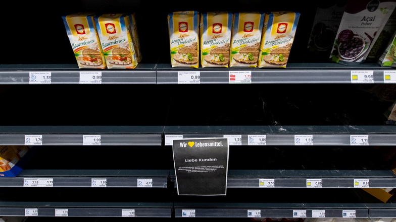 Nur noch wenige Packungen Mehl stehen in einem Regal in einem Supermarkt. Der Verkauf wurde auf zwei Packungen pro Kunde beschränkt.
