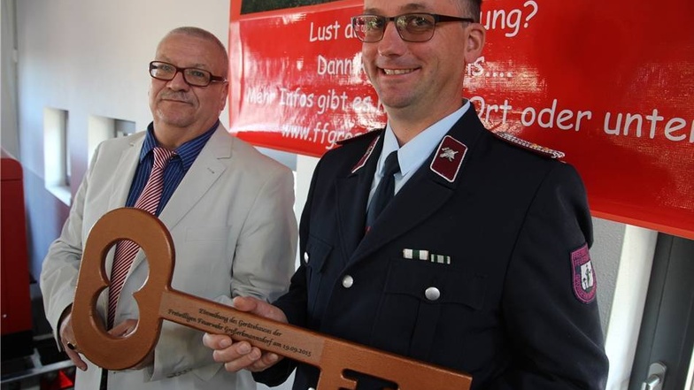 Symbolik nach der Fertigstellung: Oberbürgermeister Gerhard Lemm übergibt die Schlüssel für das neue Feuerwehrgebäude an den Großerkmannsdorfer Feuerwehrchef Falk Hempel.