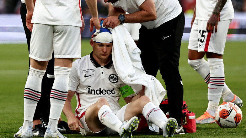 Sebastian Rode (M) von Eintracht Frankfurt wird während des Spiels medizinisch behandelt.