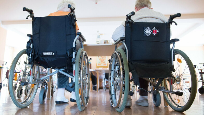 Zwei pflegebedürftige Frauen sitzen in einem Pflegeheim in ihren Rollstühlen: Die Kosten für die stationäre Pflege steigen, der Kreis soll einspringen.
