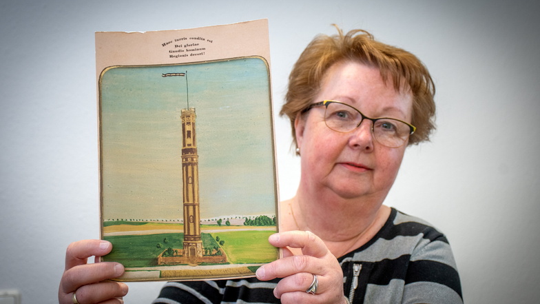 Carola Bunde, stellvertretende Vorsitzende des Vereins „Aussichtsturm Striegistal“, hat ein historisches Foto des Bauwerks in der Hand. Am Wochenende wird groß gefeiert.