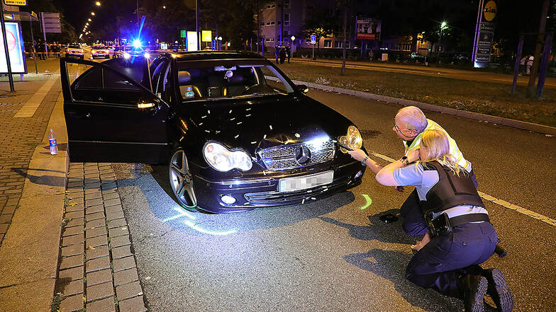 Nach dem Unfall in der Budapester Straße sichert die Polizei Spuren an einem Mercedes.