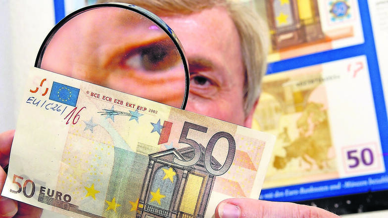 Einen gefälschten 50-Euro-Schein untersucht ein Falschgeldexperte. Die Geldscheine, die ein Meißner in Umlauf gebracht haben soll, waren auf primitivste Weise hergestellt: auf einem Tintenstrahldrucker.