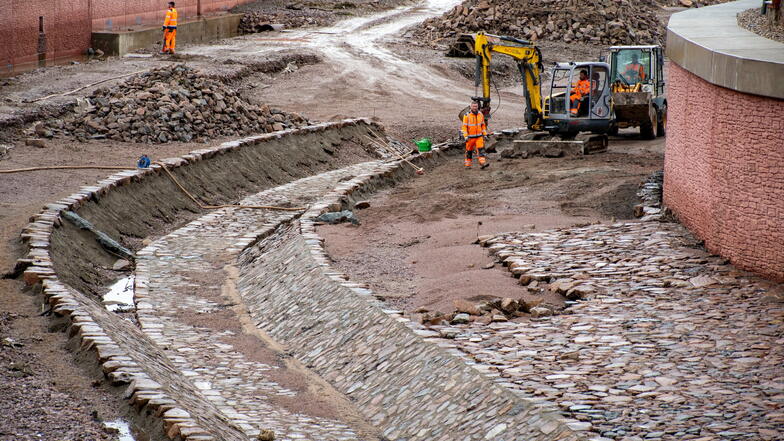 Die Mitarbeiter der Firma Swietelsky haben nach der Überflutung der Baustelle am Wochenende die Arbeiten wieder aufgenommen. Derzeit pflastern sie die Sohle des Flutgrabens.