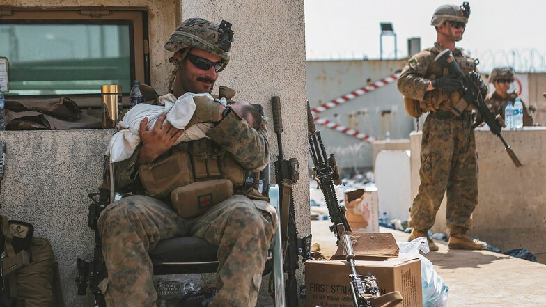 Hier kümmert sich ein US-Soldat während einer Evakuierung um ein Kleinkind.