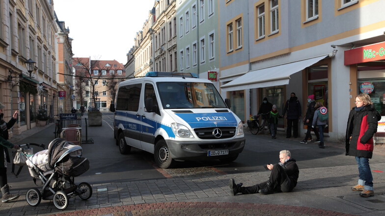 In der Pirnaer Fußgängerzone legte sich Rechts-Aktivistin Madeleine Feige vor ein Polizeiauto. Sie wurde weggetragen.