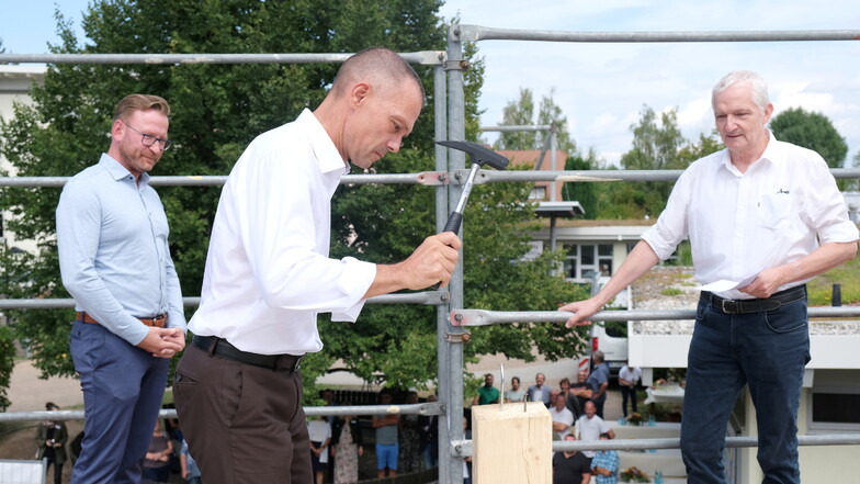 Landrat Ralf Hänsel machte einen guten Job beim Einschlagen der Nägel. Schulleiter Lars Röder (l.) und Architekt Christian Schaufel schauten zu.