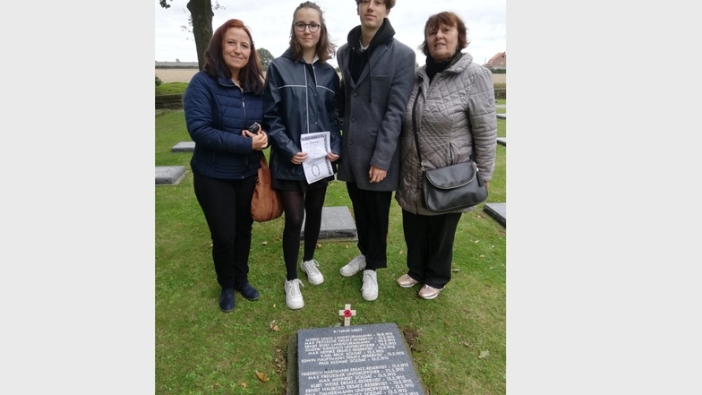 Mareen Hoch mit ihren Kindern Sienna und Demian sowie Mutter Birgit Restel (v.l.) am Grab von Opa, Uropa und Ururopa Paul Zimmermann. Er fiel hier im Ersten Weltkrieg mit 27 Jahren in Westflandern im Mai 1915.