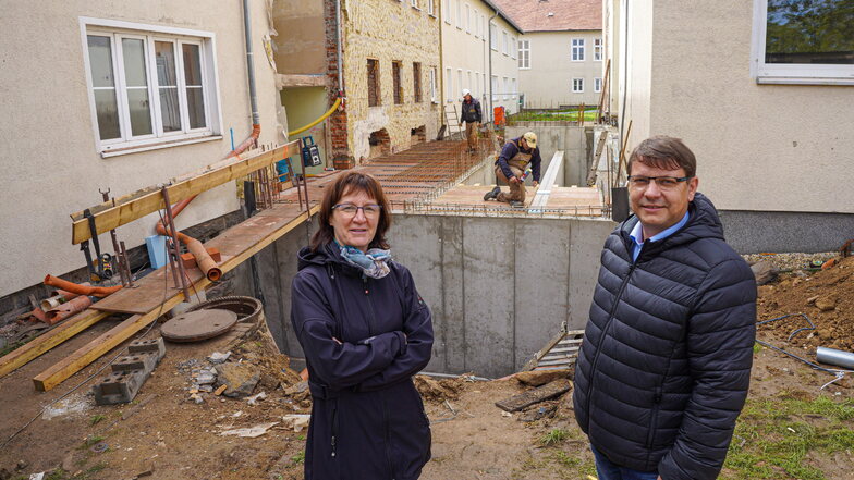 Ilona Dießner und Thomas Stahn, beide geschäftsführende Vorstände beim Berufsbildungszentrum Bautzen, stehen vor dem Eingang der künftigen Freien Gemeinschaftsschule.