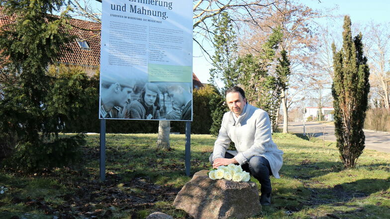 Riesas OB Marco Müller (CDU) legt weiße Rosen an der Geschwister-Scholl-Straße nieder.