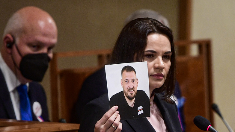Swetlana Tichanowskaja, Oppositionsführerin aus Belarus, hält ein Foto ihres inhaftierten Ehemanns Sergej Tichanowski hoch. Er wurde am Dienstag zu 18 Jahren Haft verurteilt.