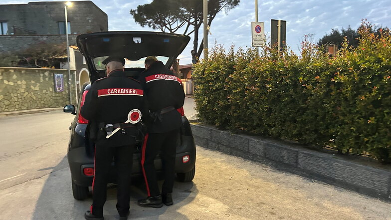 Zwei Beamte der italienischen Carabinieri an ihrem Auto.