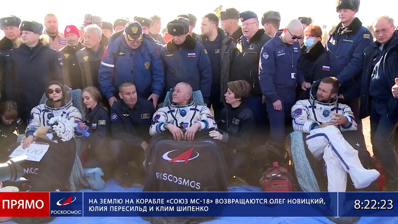 Dieses von der Raumfahrtagentur Roscosmos veröffentlichte Foto zeigt den Kosmonaut Oleg Novitskiy (M), die Schauspielerin Julia Peressild (l) und den Filmregisseur Klim Schipenko kurz nach der Landung der russischen Raumkapsel Sojus MS-18.