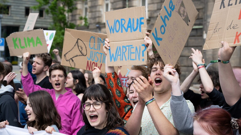 Mit selbstgebastelten Pappschildern, darunter eines mit der Aufschrift "Worauf warten?", demonstrierten Teilnehmer einer Kundgebung von Fridays for Future am Freitag vor der Staatskanzlei in Dresden.
