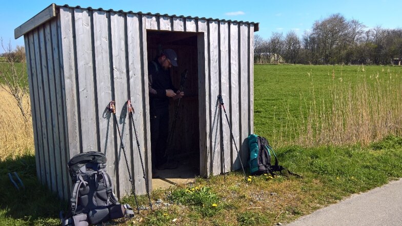 Wo Wald fehlt mit einem Netz an Wanderstrecken, gibt es auch keine Schutzhütten. So bleibt beim Langstreckenwandern mitunter das Wartehäuschen die einzige Möglichkeit, um wie hier Peter Anderson in Nordfriesland windgeschützt eine Pause einzulegen.
