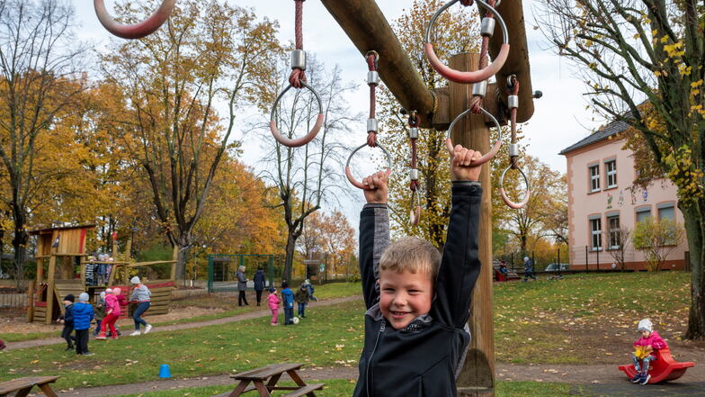 Der fünfjährige Charlie hangelt auf dem Spielplatz der ASB-Kita "Zwergenhaus" in Gröditz. Hier fühlen sich die Kinder wohl. - In Sachsen ist es Gesetz, dass auch die Eltern an den Betriebskosten beteiligt werden.
