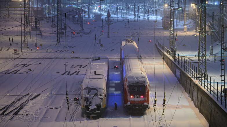 Ein Trilex-Zug steht am Montag neben einer S-Bahn auf verschneiten Gleisen am Dresdner Hauptbahnhof.