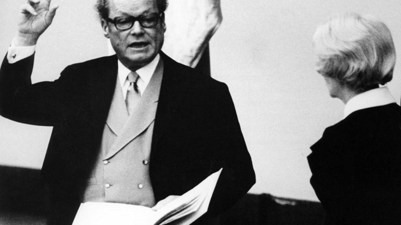 Willy Brandt legte wenige Stunden nach seiner Wiederwahl am 14. Dezember 1972 im Deutschen Bundestag in Bonn den Amtseid ab. Rechts Annemarie Renger, die als erste Frau im Amt des Bundestagspräsidenten die Vereidigung vornahm.