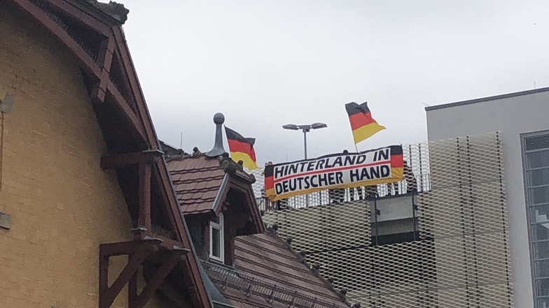 Zu Beginn der Veranstaltung hatten einige Gegendemonstranten auf dem Dach des REWE-Parkhauses am Bahnhof Radebeul Ost ein Banner entrollt.
