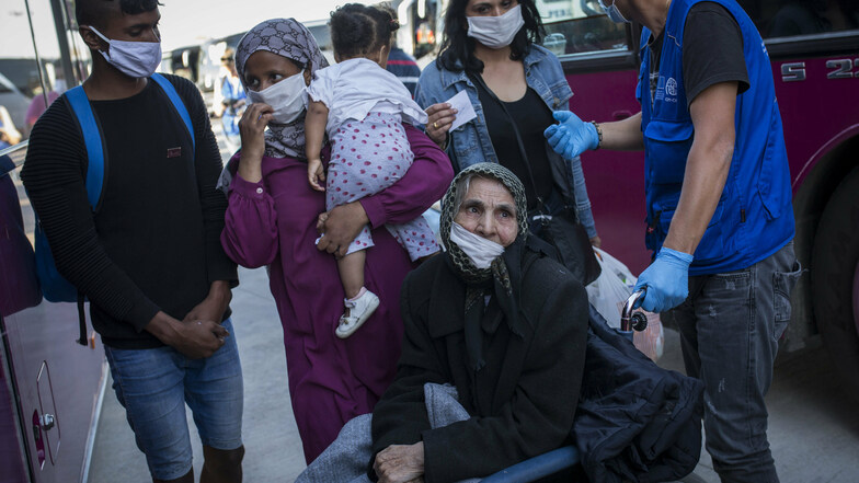 Flüchtlinge aus Moria und von anderen griechischen Inseln stehen im Hafen von Lavrio bei Athen. Griechische Behörden verlegten etwa 1.000 Migranten, zumeist Familien und anerkannte Flüchtlinge, auf das Festland.