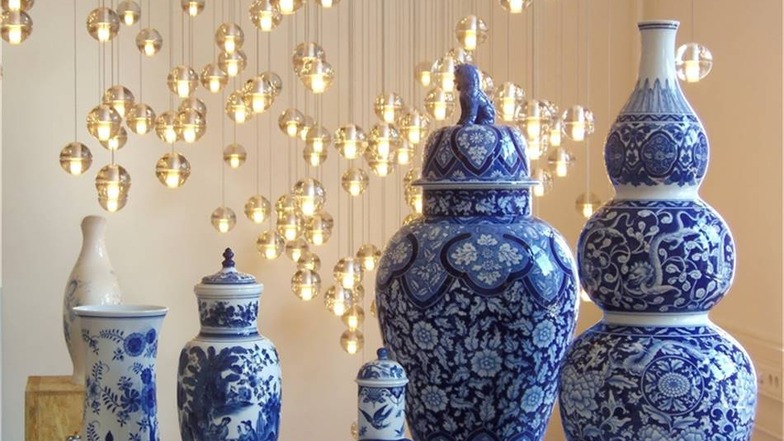 Wie goldene Tropfen schwingen die Bocci-Leuchten über dieser farblich beeindruckenden Collage von Vasen in Indisch-Blau-Malerei.