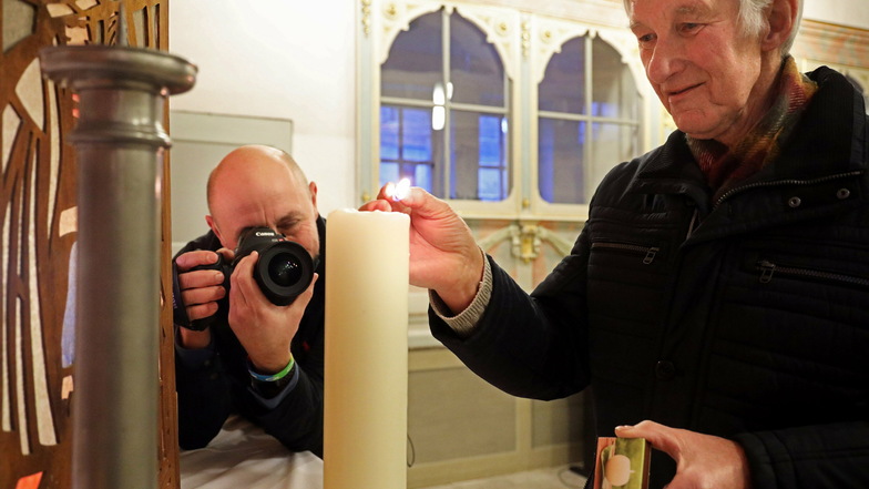 Film ab: Kurator Johannes Stolle (r.) zündet in der Gröbaer Kirche eine Kerze an, Marco Branig von Riesa-TV filmt. Die Aufnahmen entstehen für einen Video-Gottesdienst, der auch im Lokalfernsehen laufen soll.