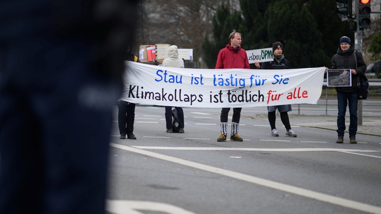Teilnehmer einer Straßenblockade von Klimaaktivisten am Fritz-Förster-Platz in Dresden demonstrieren am Donnerstag für einen gerechten Klimaschutz.