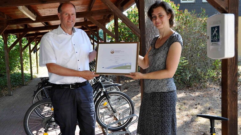 Die stellvertretende Vorsitzende des ADFC Sachsen, Rosalie Kreuijer, übergibt dem Geschäftsführer von Sachsenforst, Utz Hempfling, das Zertifikat als fahrradfreundlicher Arbeitgeber für den Standort Graupa in Bronze.