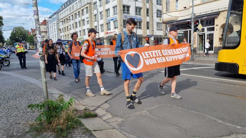 Demonstranten von "Letzte Generation" am Mittwochnachmittag auf der Königsbrücker Straße. Mit einem Protestzug haben sie kurzzeitig den Verkehr behindert.