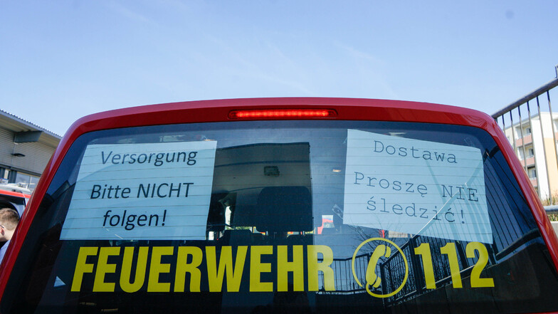 Schilder in deutscher und polnischer Sprache hängen im Heck der Versorgungsfahrzeuge. Sie warnen davor, den Fahrzeugen zu folgen.