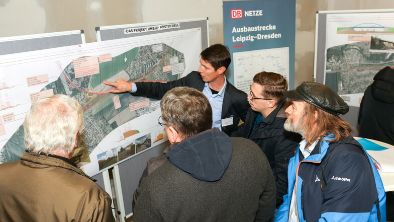 Projektleiter Lars Enzmann erläutert an einer Tafel die Baumaßnahmen im Bereich Riesaer Bahnhof, die 2029 beginnen sollen.