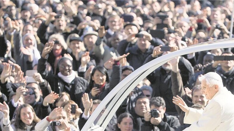 Mit dem Papamobil lässt sich Benedikt vor der letzten Generalaudienz auf dem Petersplatz durch die Menge jubelnder Pilger fahren.Foto: dpa/Michael Kappeler
