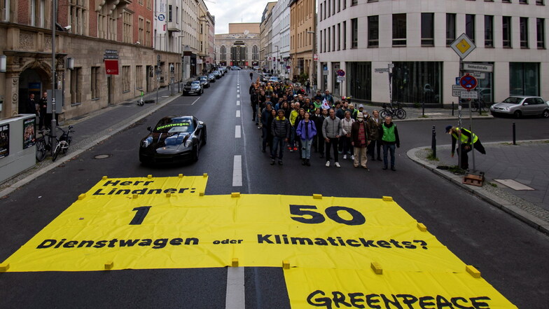 Greenpeace-Protestaktion vor der FDP-Bundeszentrale: Nach Informationen von Greenpeace kostet die Förderung eines Porsche 911 als Dienstwagen dem Staat so viel Geld wie der Zuschuss zu 50 Klimatickets für einen Jahrespreis von maximal 365 Euro.