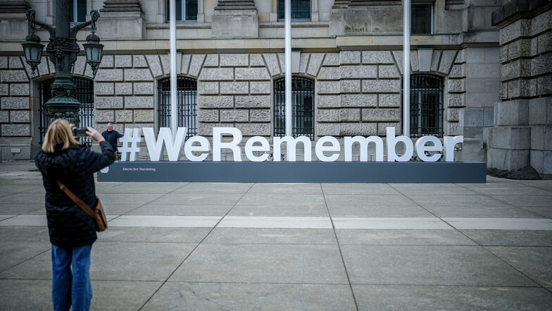 Der Schriftzug „#WeRemember“ steht anlässlich des Internationalen Tages des Gedenkens an die Opfer des Holocaust vor dem Reichstagsgebäude mit Deutschen Bundestag.