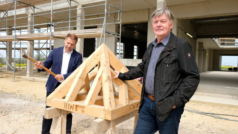 Der Rohbau des neuen Schulgebäudes in Klipphausen ist fertiggestellt. Bürgermeister Mirko Knöfel (links) schlägt gemeinsam mit Alt-Bürgermeister Gerold Mann den letzten Nagel ein.