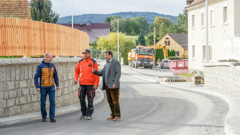 SLB-Geschäftsführer Silvio Buchhorn (v. r.), Polier René Häßler und Bürgermeister Olaf Reichert sind guter Dinge: Die Ortsdurchfahrt in Jenkwitz verleiht dem Dorf ein neues Gesicht. Der Weg dahin war kompliziert.